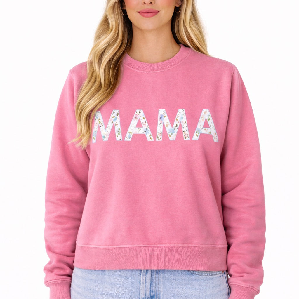 Woman wearing a pink sweatshirt with 'MAMA' text on a white background